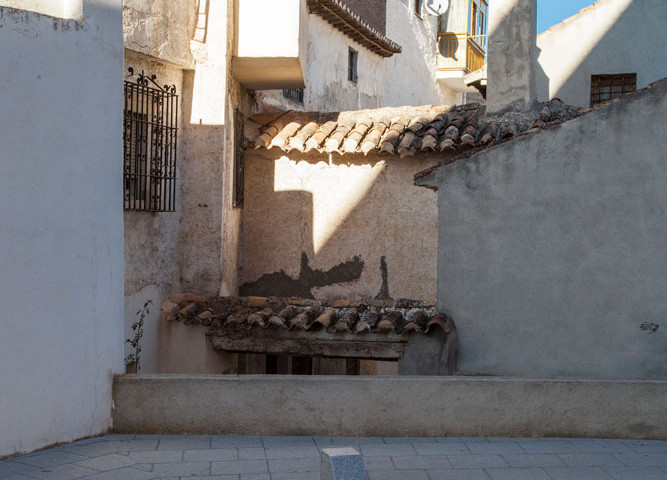 un murete oculta la visión del callejón del Mesón